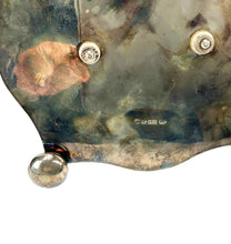 Load image into Gallery viewer, Close-up of a textured metal surface with two screws and a drop of liquid.