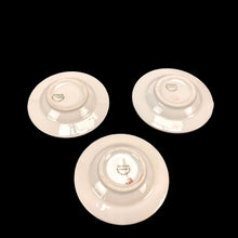 Load image into Gallery viewer, Three white ceramic plates with visible branding on a black background