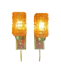 Lade das Bild in den Galerie-Viewer, Two orange wall sconces with decorative glass shades on a white background