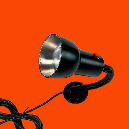Black spotlight with a flexible cord on an orange background