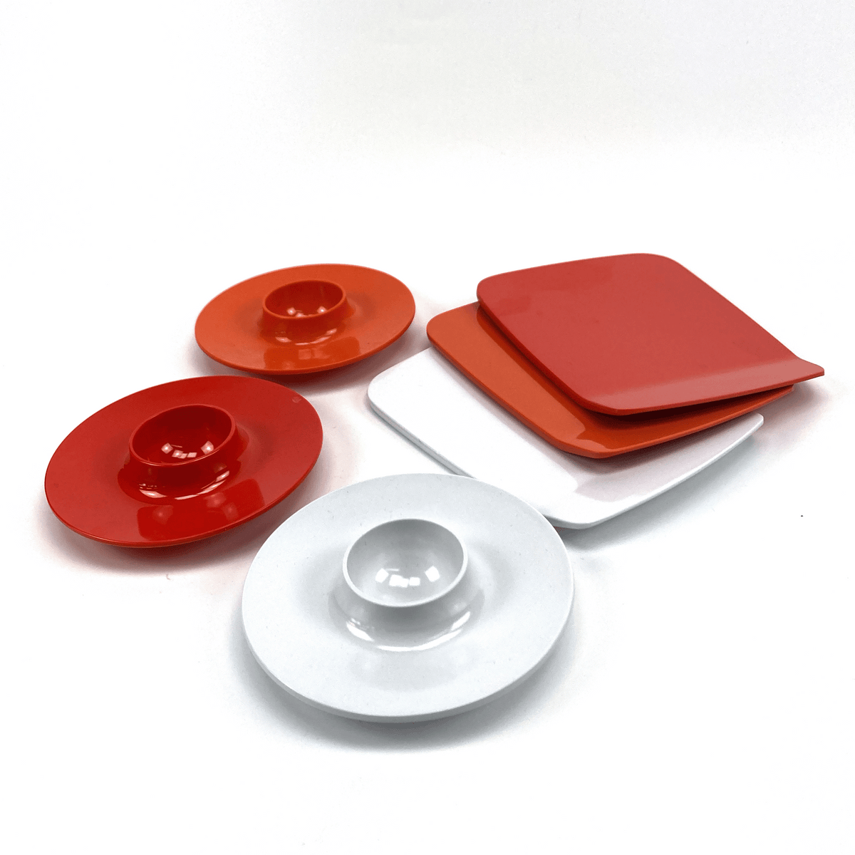 Set of red and white melamine plates on a white background