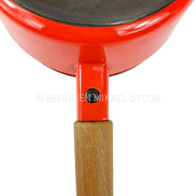 Load image into Gallery viewer, Close-up of a red frying pan with a wooden handle on a white background, featuring the Bendixen Mikael Decor brand.

