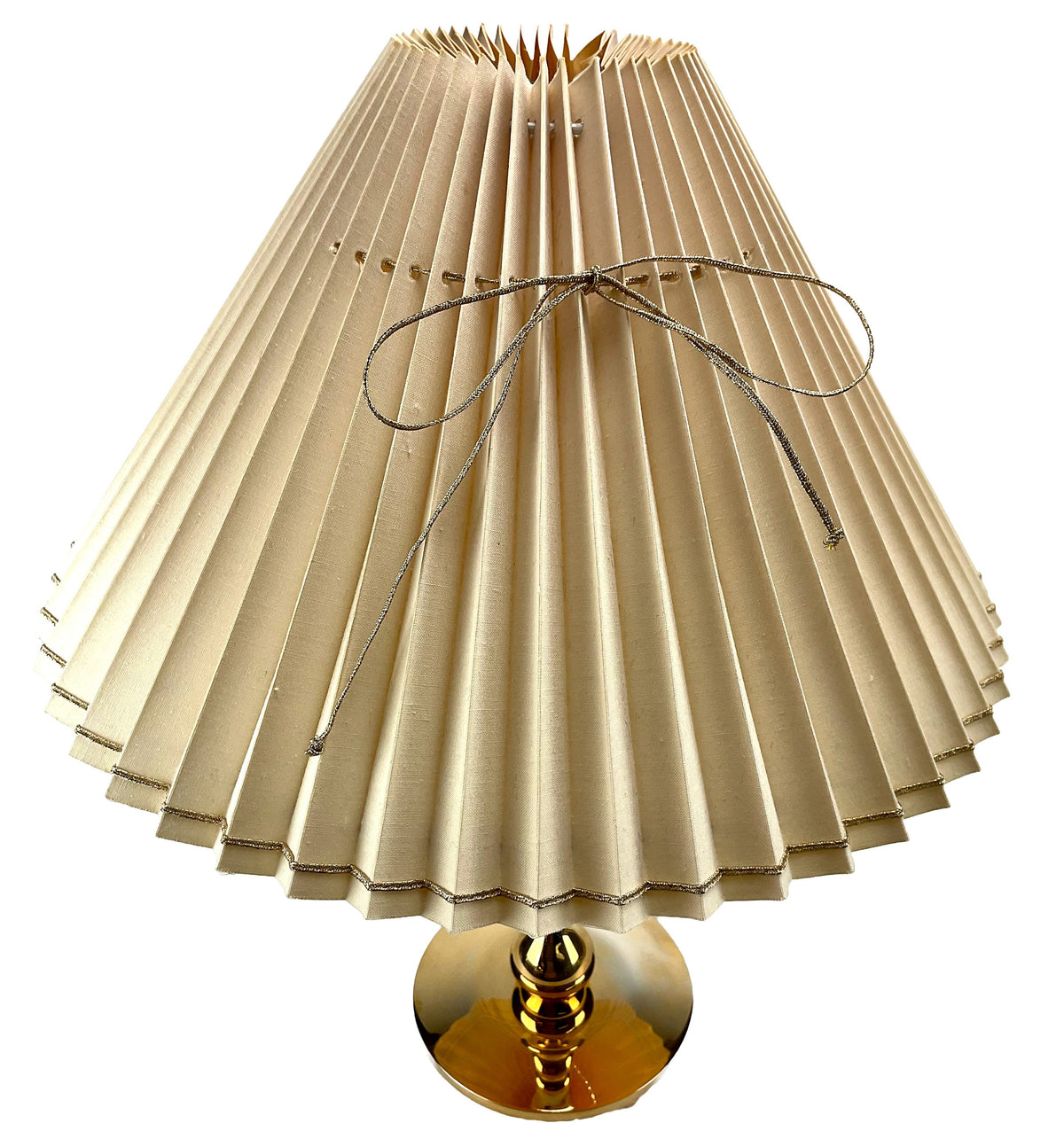 Beige pleated lampshade with a gold base on a white background