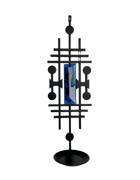 Black geometric decorative object with a blue centre on a white. Dantoft Danish Mid-Century Brutalist Candle Holder. Black Iron & Blue Glass, 1960s.background