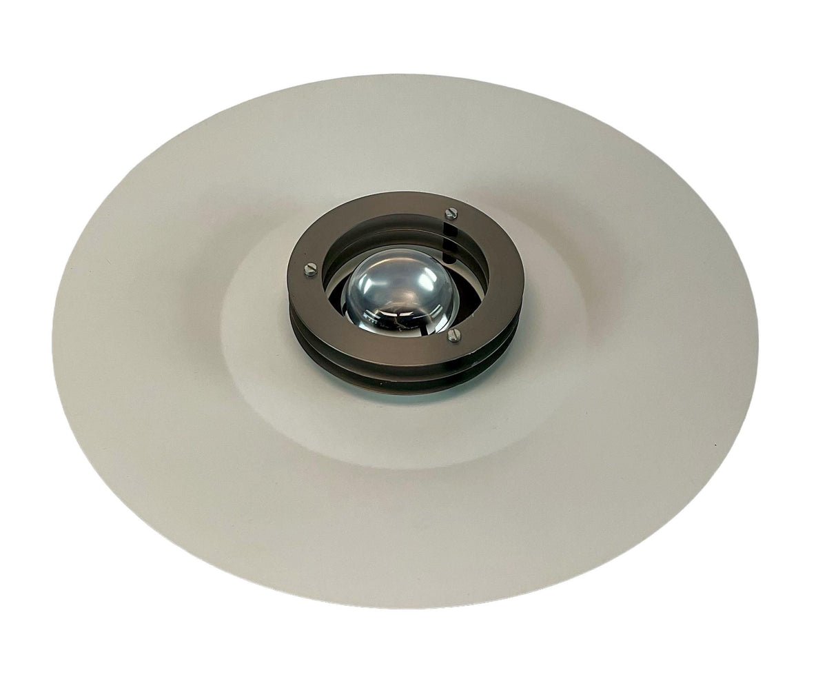 Round metallic object with a central glass component on a white background
