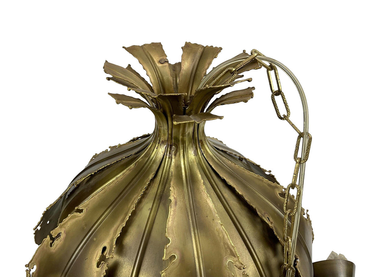 Close-up of a decorative brass lamp with intricate design on a white background