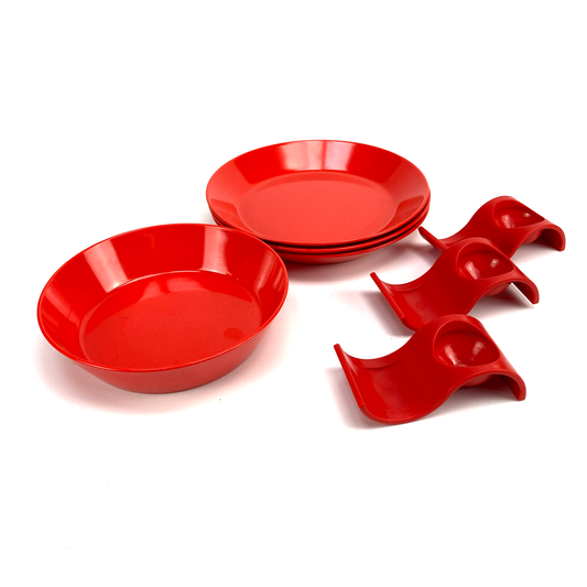 Set of red melamine plates and serving dishes on a white background