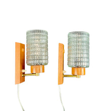 Load image into Gallery viewer, Pair of wall sconces with glass shades and wooden bases on a white background
