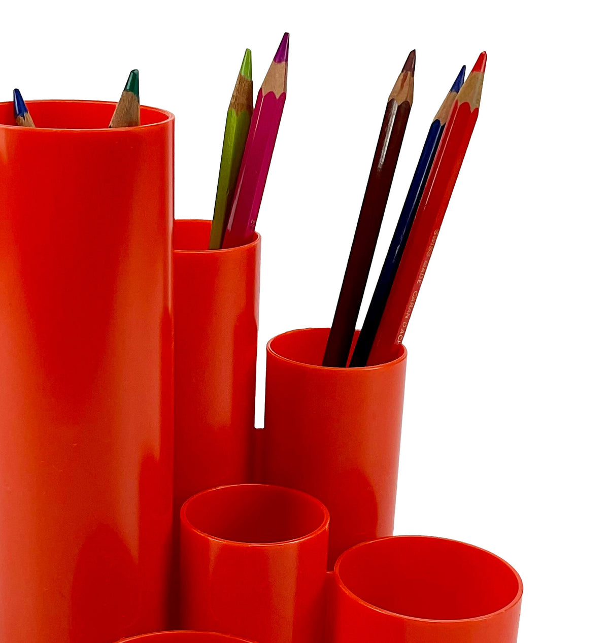 Red cylindrical holders with colored pencils on a white background