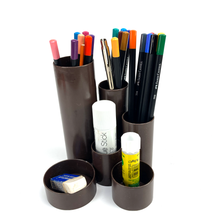 Lade das Bild in den Galerie-Viewer, Set of markers, pens, and other stationery items in a brown cylindrical holder on a white background
