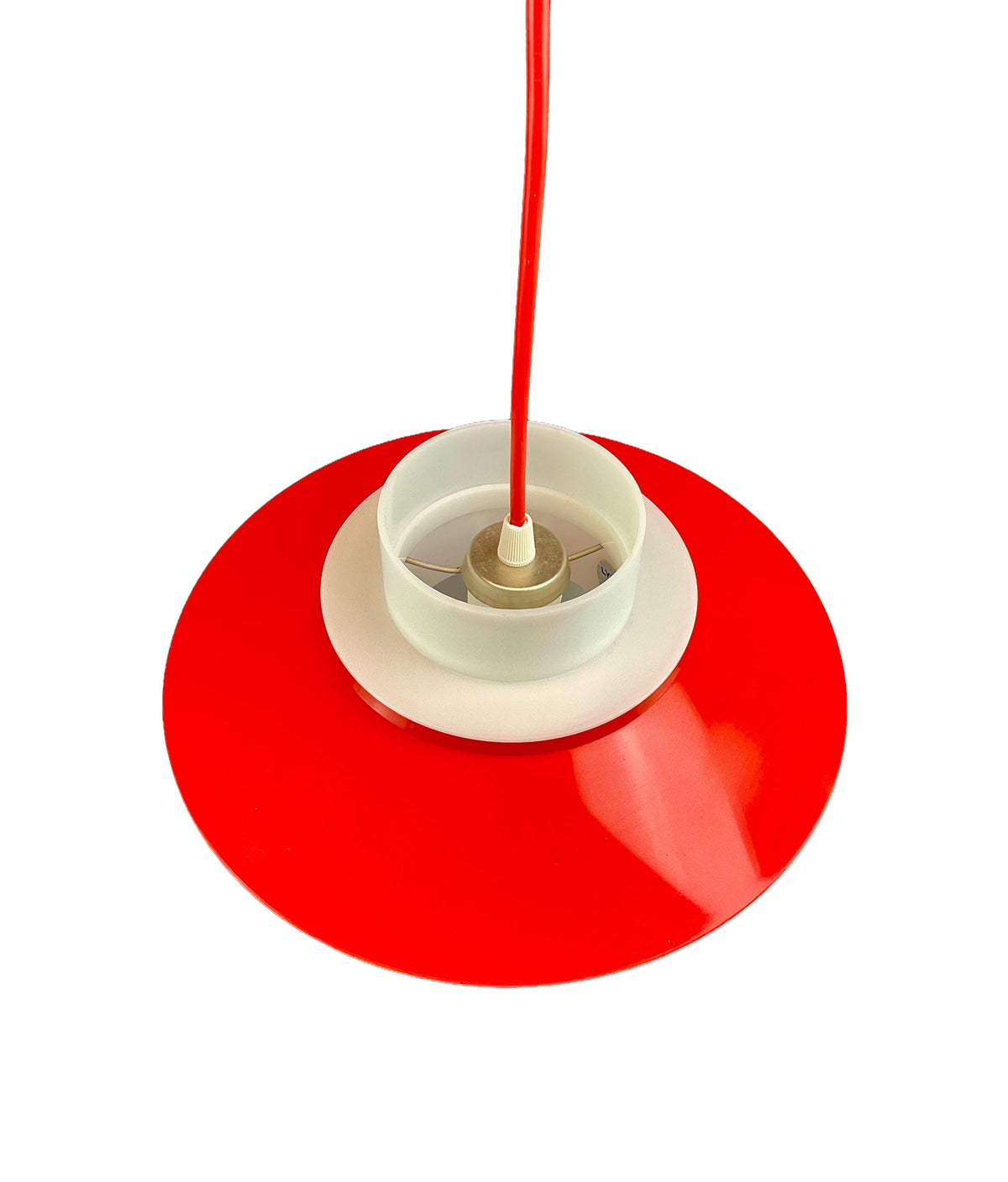 Red and white lampshade with a visible light bulb on a white background