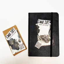 Load image into Gallery viewer, Black notebook with &#39;CWU ART&#39; design on a white background. The Circulated Canvas: A Create-With-Us Chain Sketchbook
