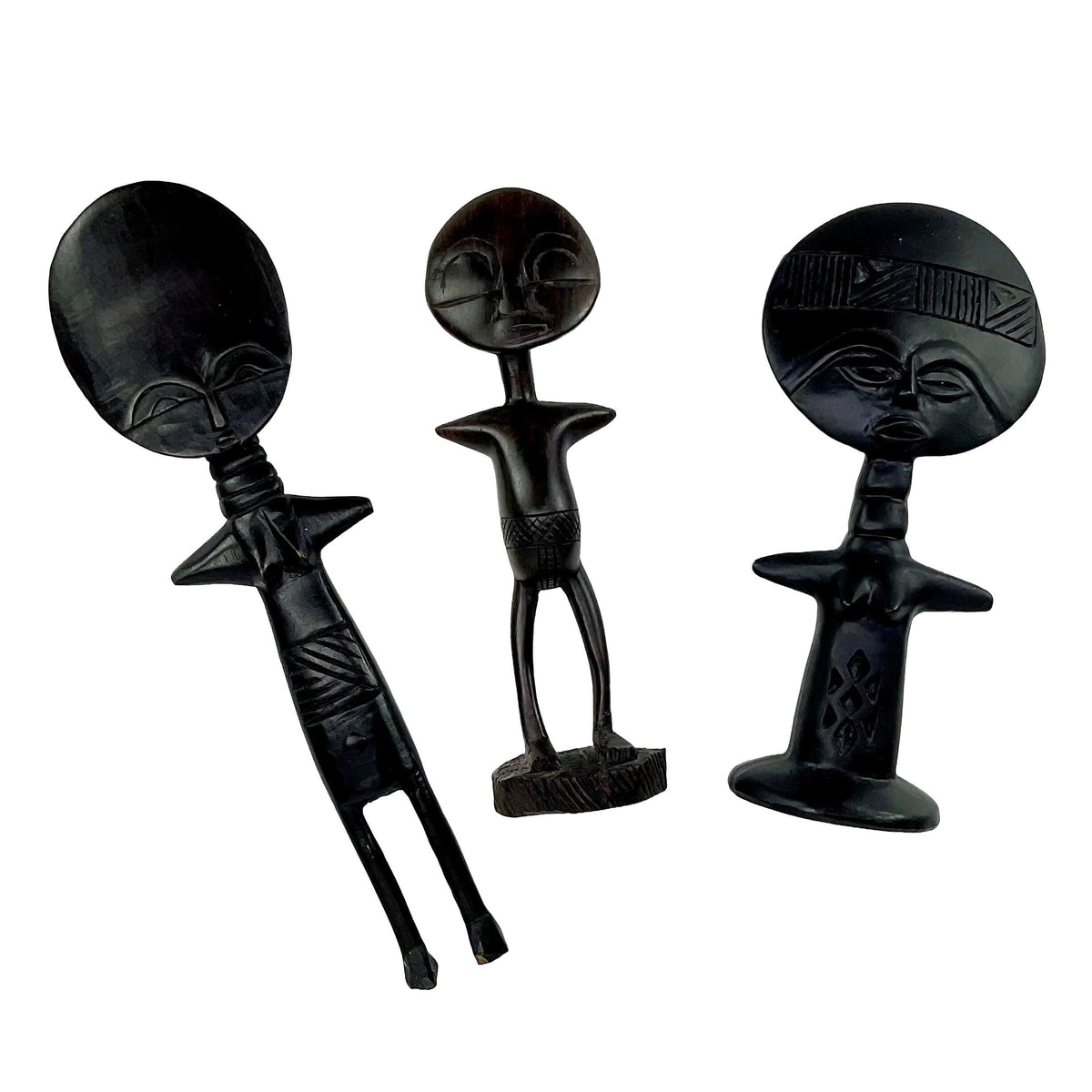 Three black ceramic figures with tribal designs on a white background