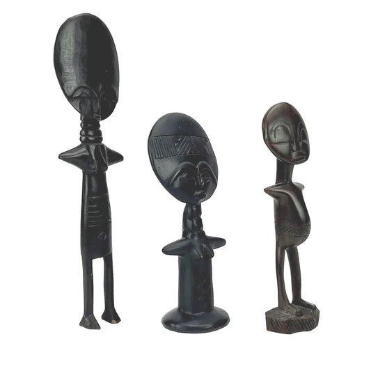 Three black figurines with detailed faces on a white background