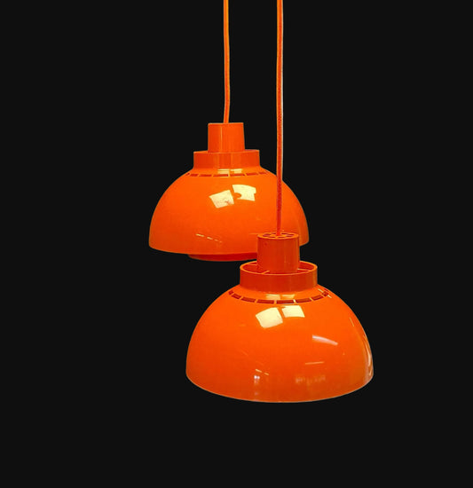 Two orange pendant lights on a black background