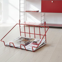 Load image into Gallery viewer, A vintage red vinyl-covered wire basket designed for wall-mounted shelf storage, featuring a grid-like design and containing magazines.
