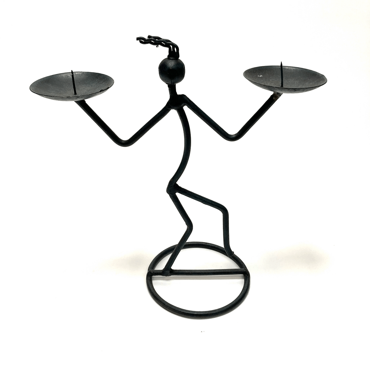 Black metal candle holder shaped like a person with two candles on either side on a white background