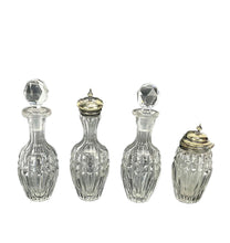 Load image into Gallery viewer, Four clear glass bottles with silver lids on a white background
