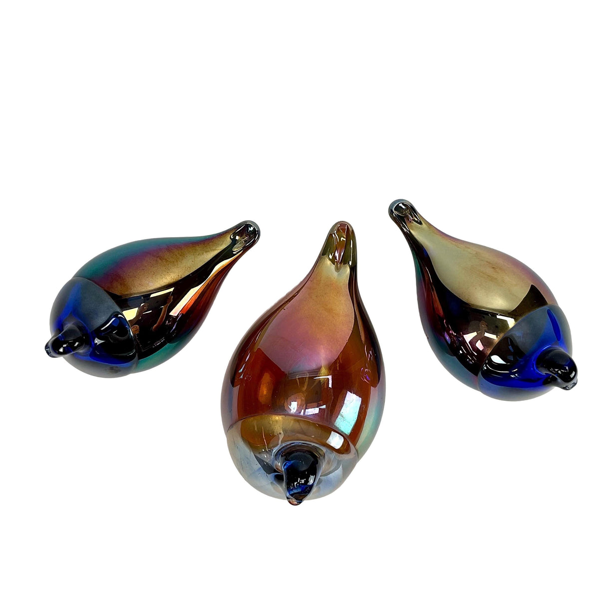 Three multicolored glass teardrop-shaped birds on a white background