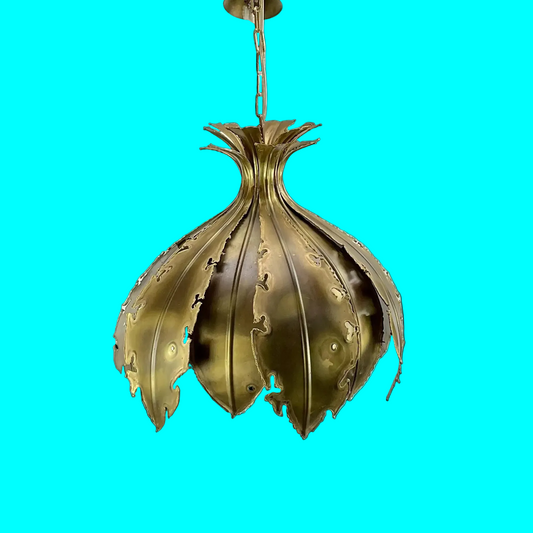 Decorative brass pendant light against a blue background
