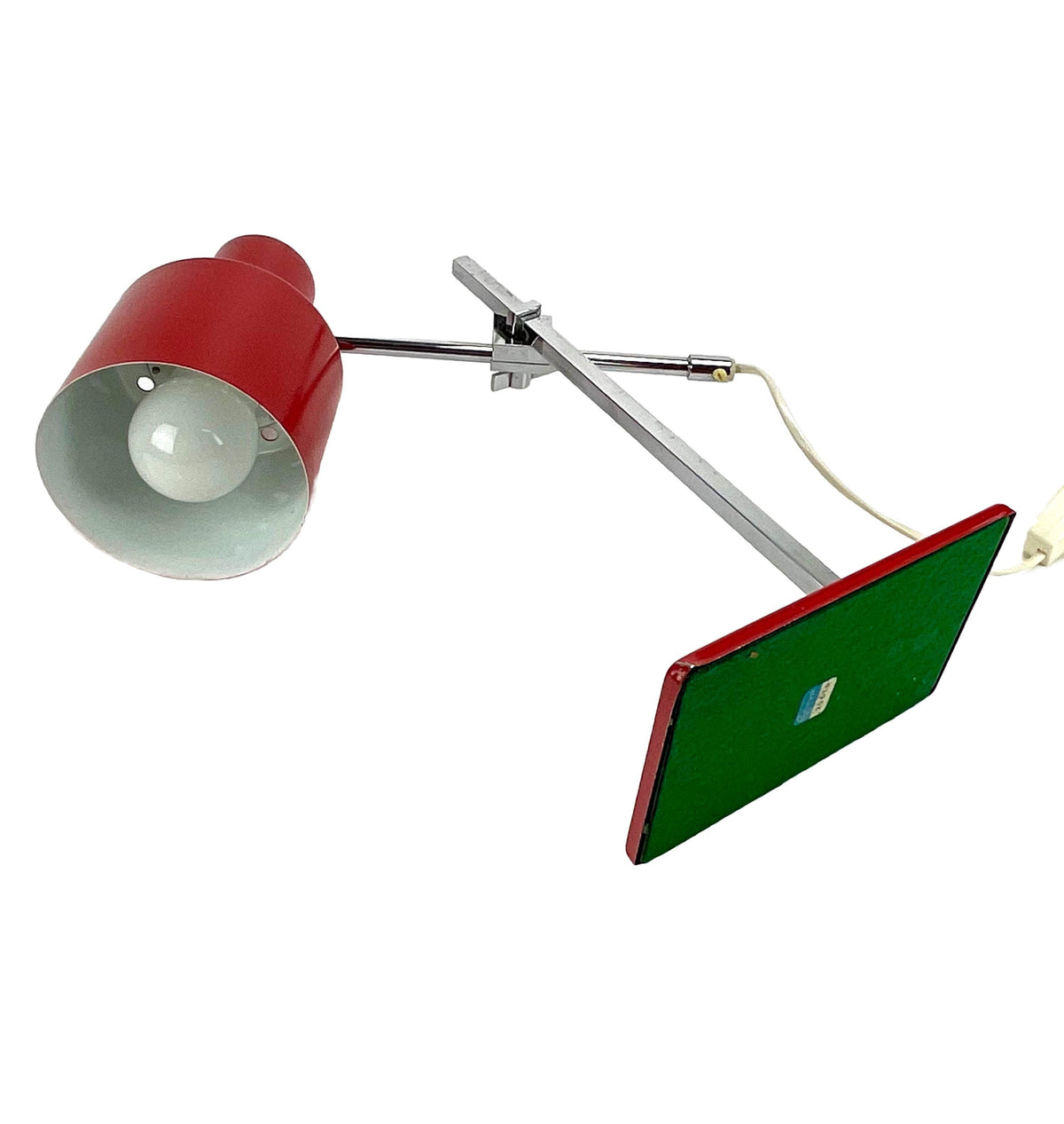 Table lamp with a red shade and green base on a white background